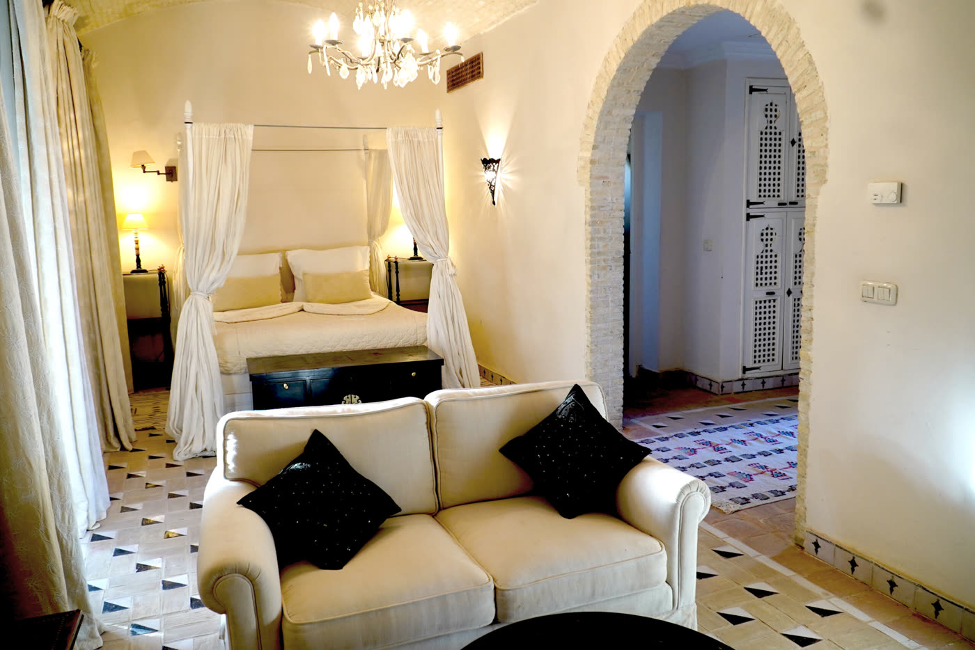 Guest room with a four-poster bed and a tiled archway