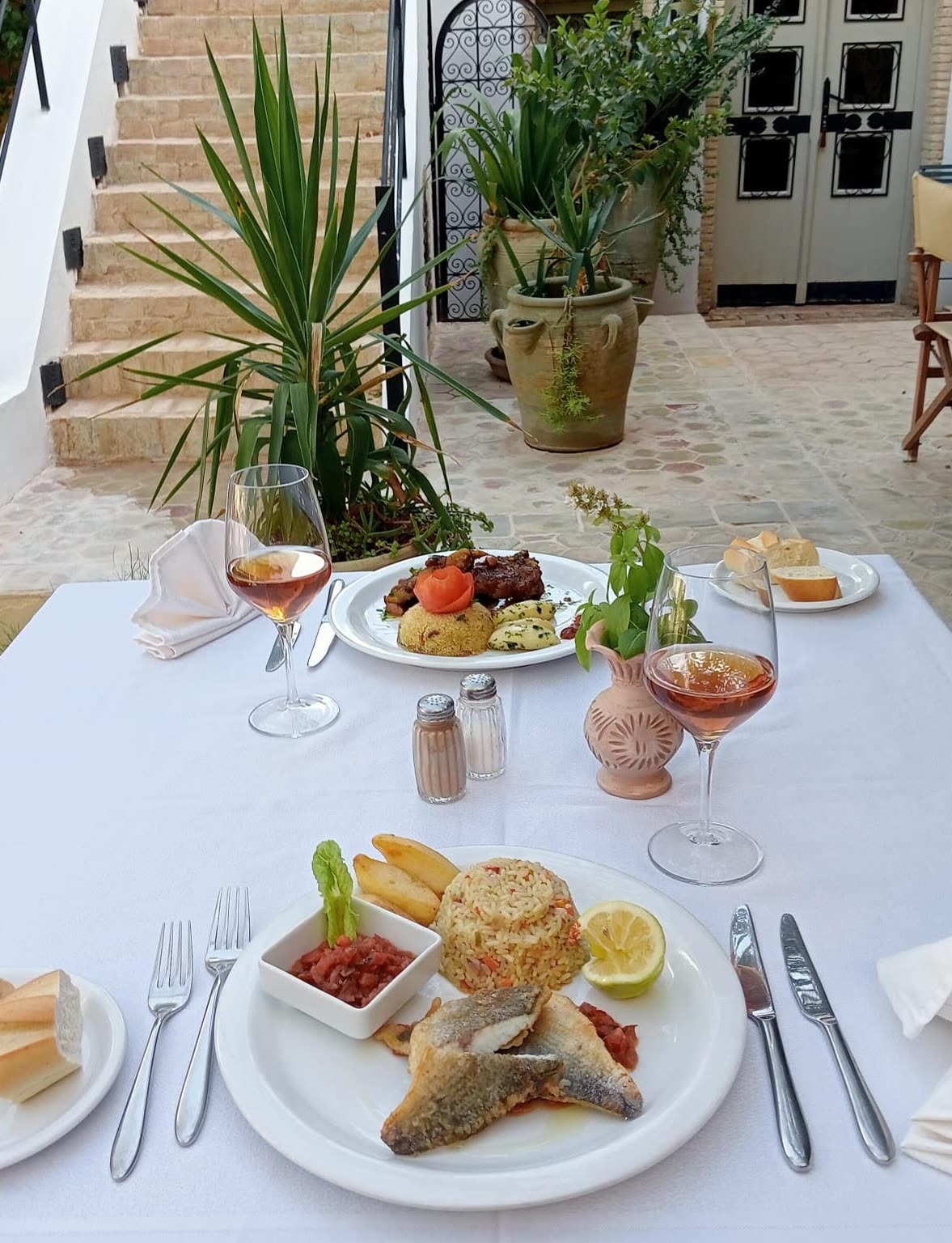 A table laid for lunch in a planted courtyard