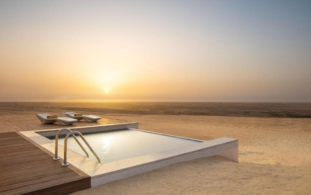 Infinity pool at the edge of the desert at sunset